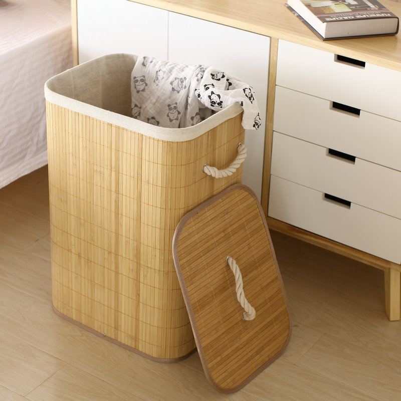 Tall natural bamboo laundry hamper with open lid in a modern bedroom setting