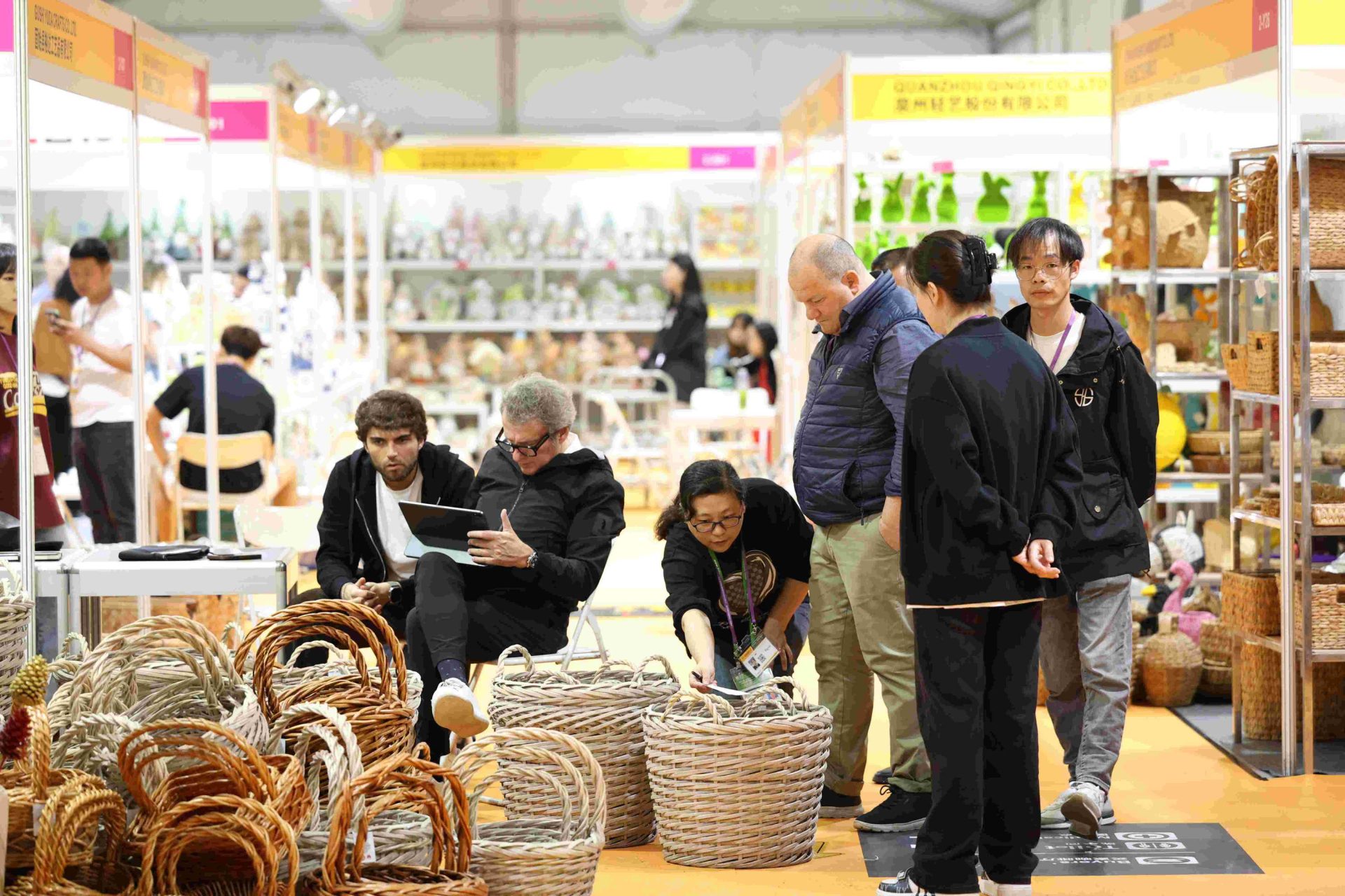 WovenNatural team showcasing handmade natural woven baskets at an international home decor trade show, meeting global buyers