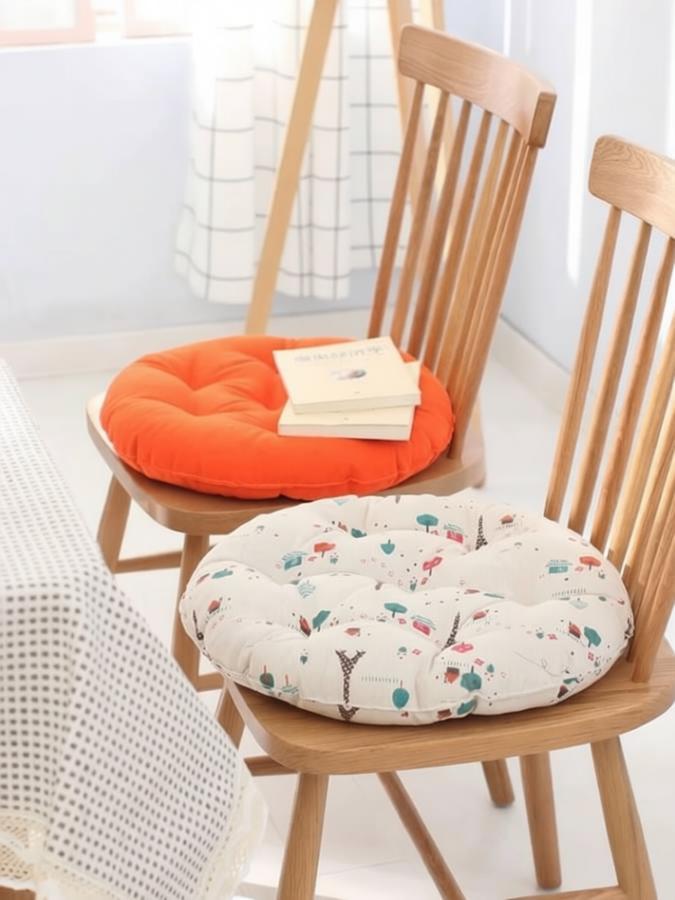 Patterned and solid color tufted cushions placed on solid wood dining chairs for home and hotel canteen seating upgrade