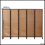 Folding bamboo room divider separating a seating area from a dining space