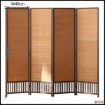 Folding bamboo room divider used as a freestanding partition in a bedroom