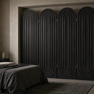 Tone on tone black arch screen closing a bedroom alcove in a moody grey suite interior