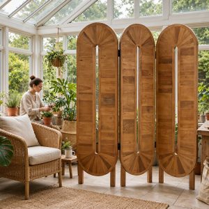 Slotted teak oval privacy screen panels with sunburst veneer crowns standing among plants in a glass conservatory