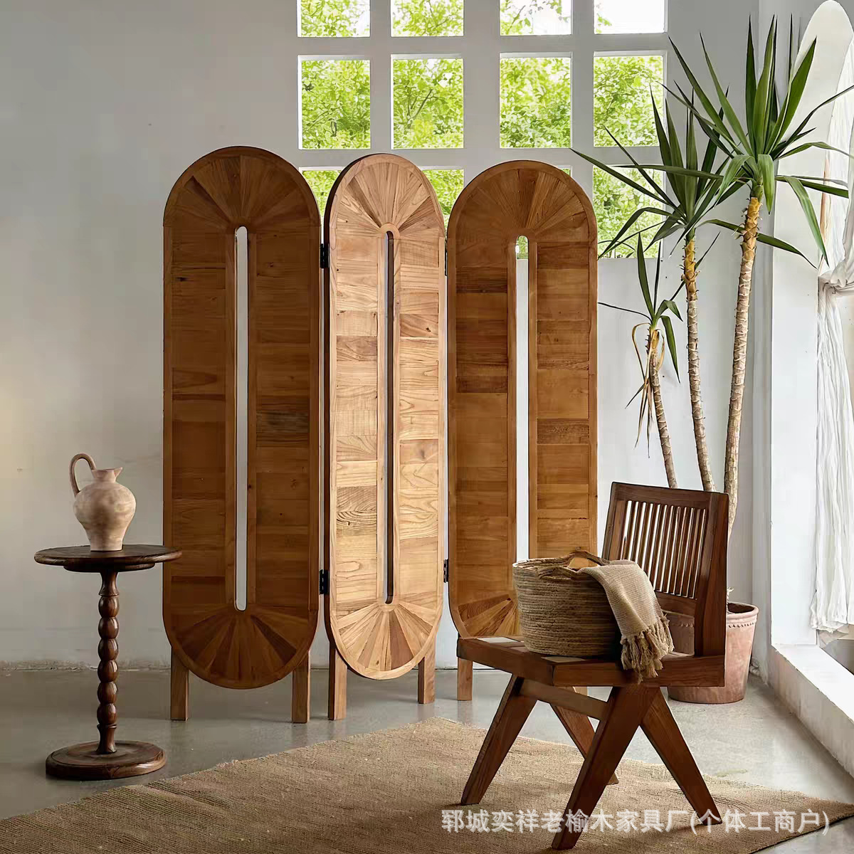 Veneer rays fanning from a vertical slot in three staggered oval teak screen panels in a white interior