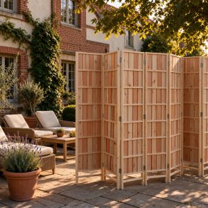 Slatted timber folding screen on a stone courtyard beside terracotta pots at golden hour