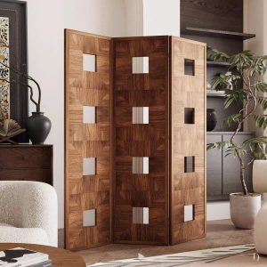Stacked square openings of a veneer room divider beside a sideboard and dried branch vase in a hallway entry